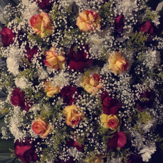 Coroa de flores com rosas amarelas e vermelhas